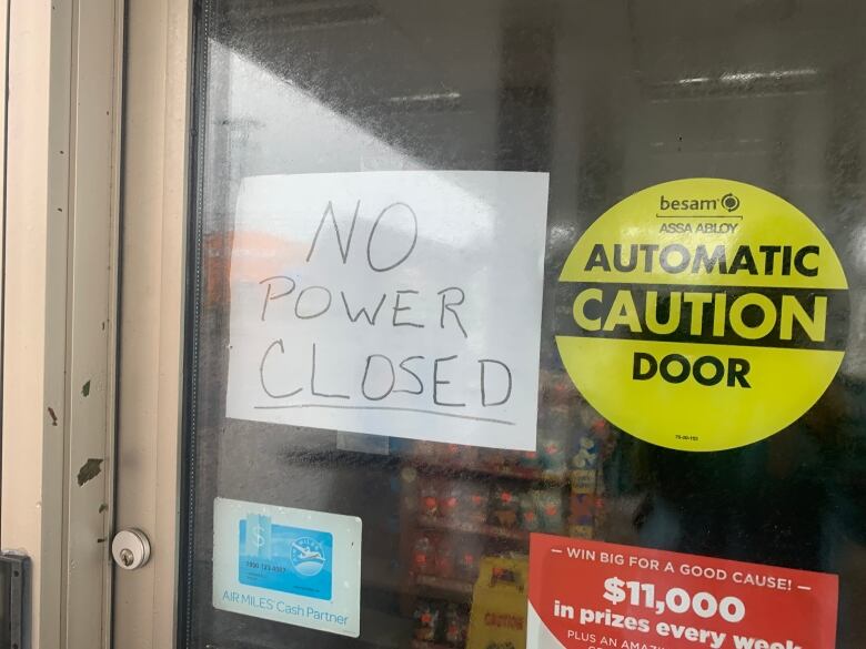 A handwritten sign on the door of a business reads, 