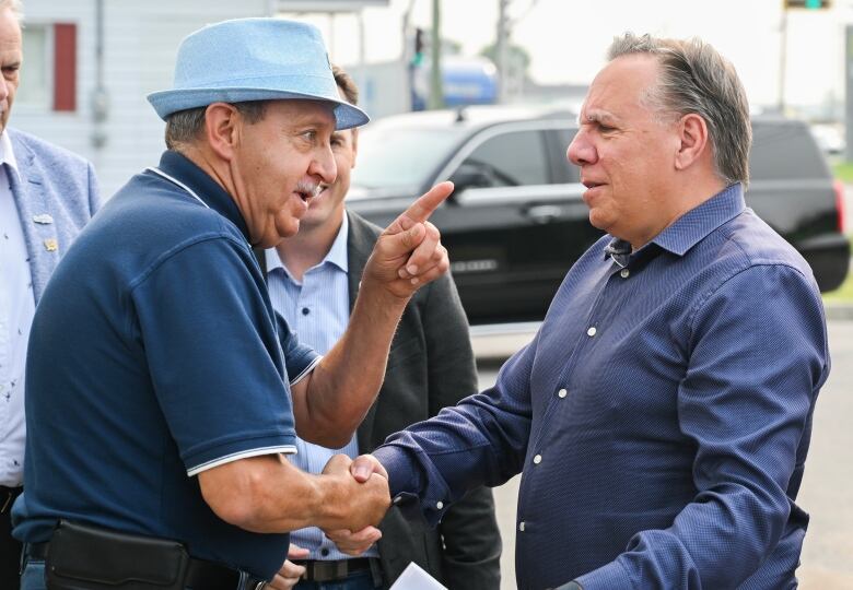 Two men talking to each other, one pointing