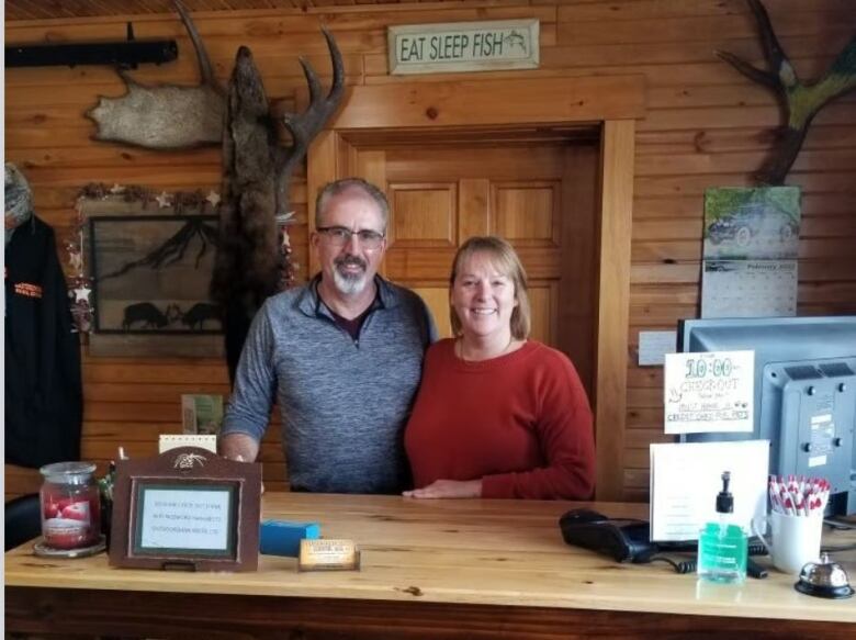 Middle-aged man and woman standing at a front desk