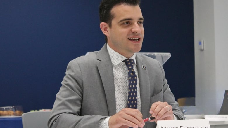 A man speaks while at a table