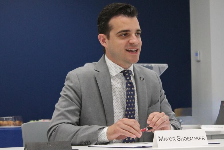 A man speaks while at a table