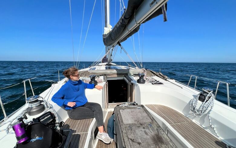 A woman in sunglasses sits on a boat.