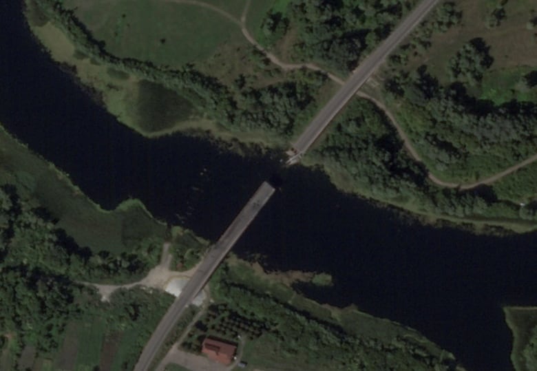 A satellite image shows a bridge collapsed over a river.