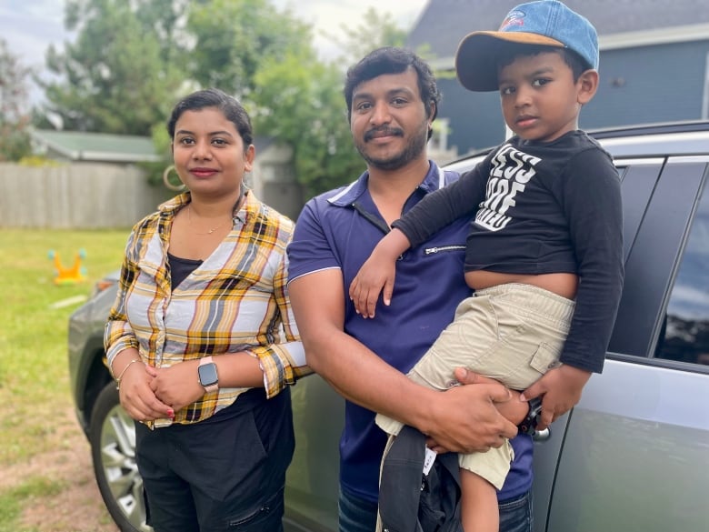 A man, woman and child stand in a group photo.