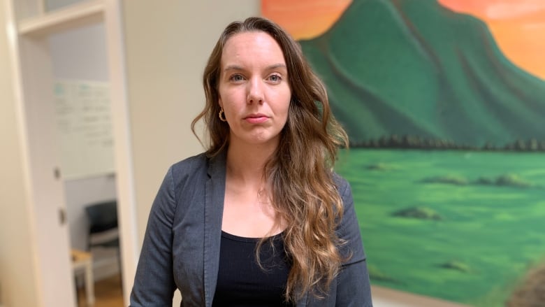 A woman in hallway with painting behind her