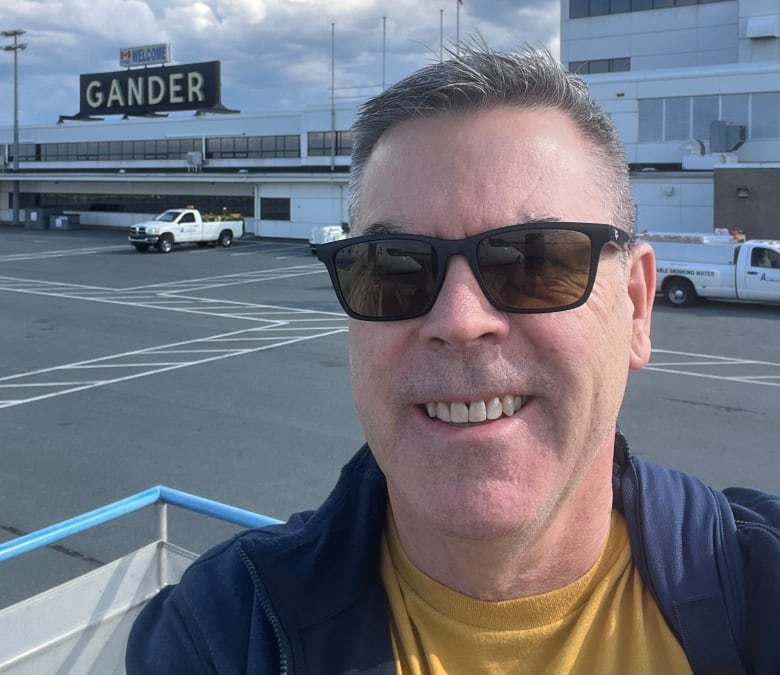 A man stands on the runway of Gander International Airport.