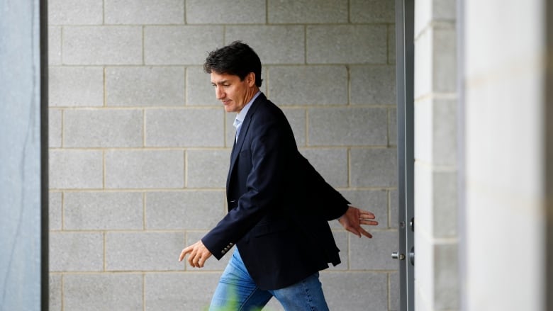 Prime Minister Trudeau walking in front of a wall. 