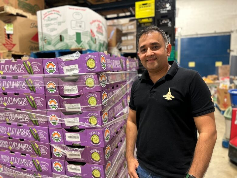 Man standing in front of vegetable pallets