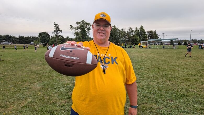 Rob Dennis holding a football.