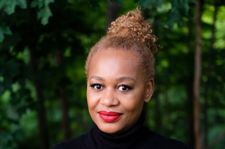 The photo shows Nneka MacGregor, the executive director of the Women Centre for Social Justice with a wooded area in the background. 