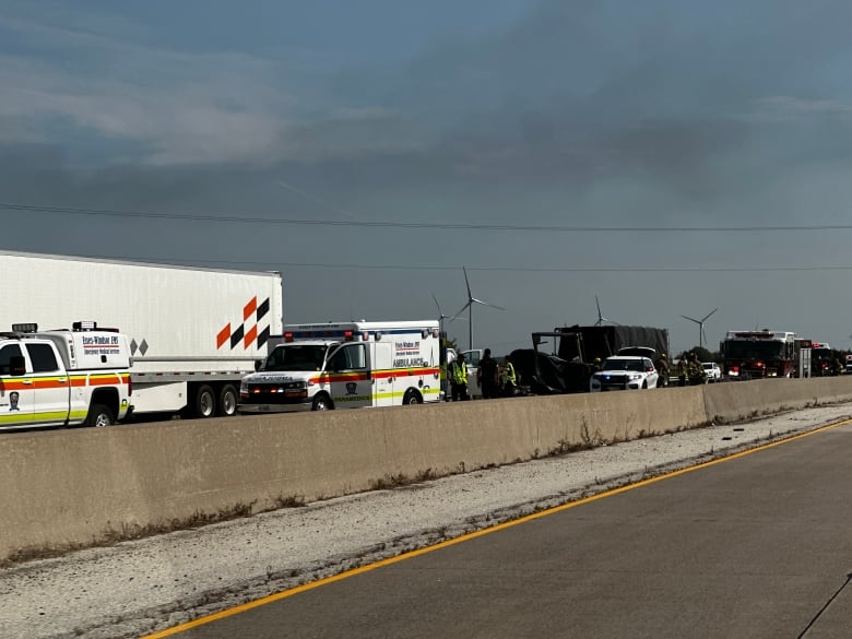 Emergency vehicles are shown near an accident in the westbound lanes of Highway 401 near Comber, Ont., on Aug. 23, 2024.