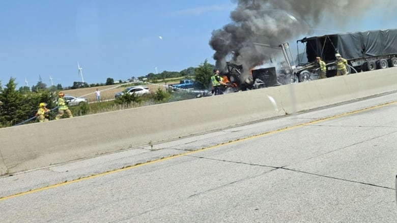 Fire crews work to put out a vehicle fire following a multi-vehicle accident on Highway 401 in Comber, Ont., on Aug. 23, 2024.