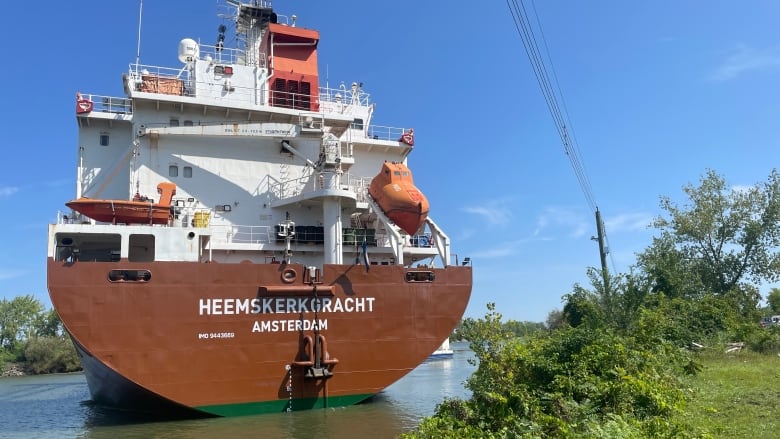 A large cargo ship on a small canal on a sunny day