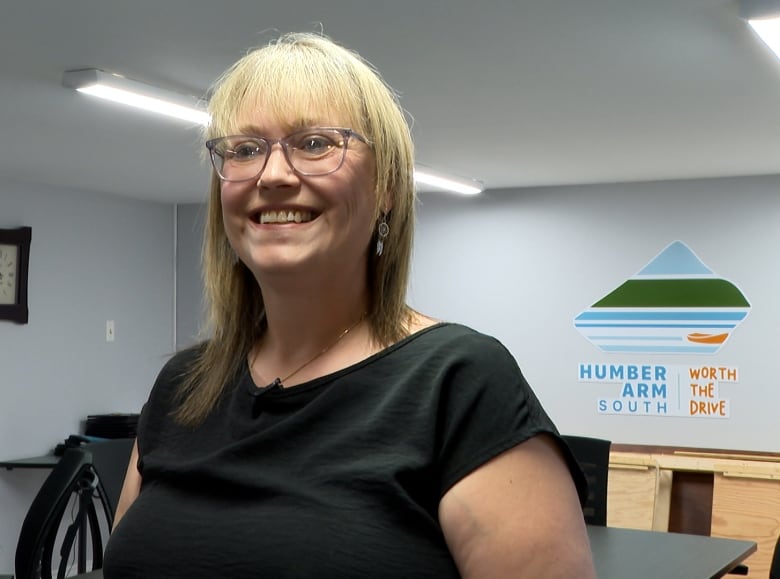 A woman with glasses smiling.