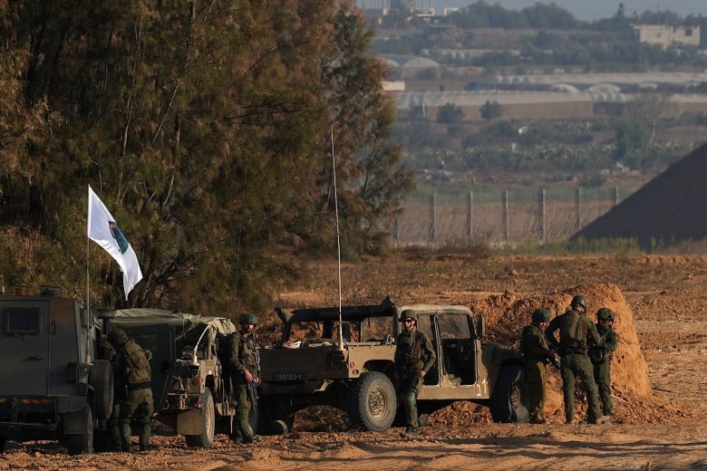 Israeli soldiers stand next to military vehicles near the Israel-Gaza border, amid the Israel-Hamas conflict, in Israel, August 23, 2024.