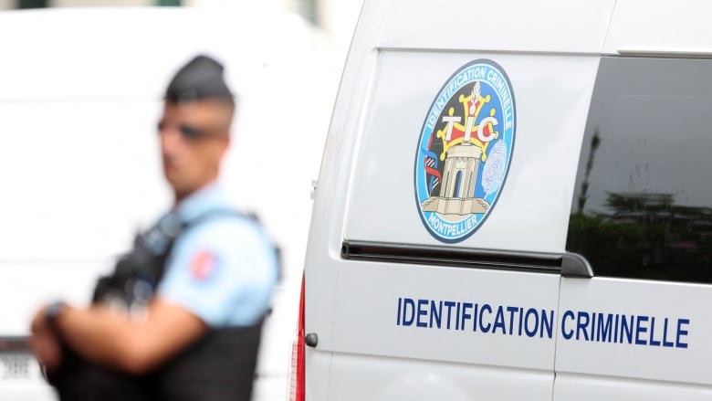 A police officer stands next to a van.