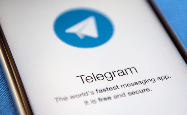 A close up of a smartphone screen displays a logo for the Telegram messaging app.