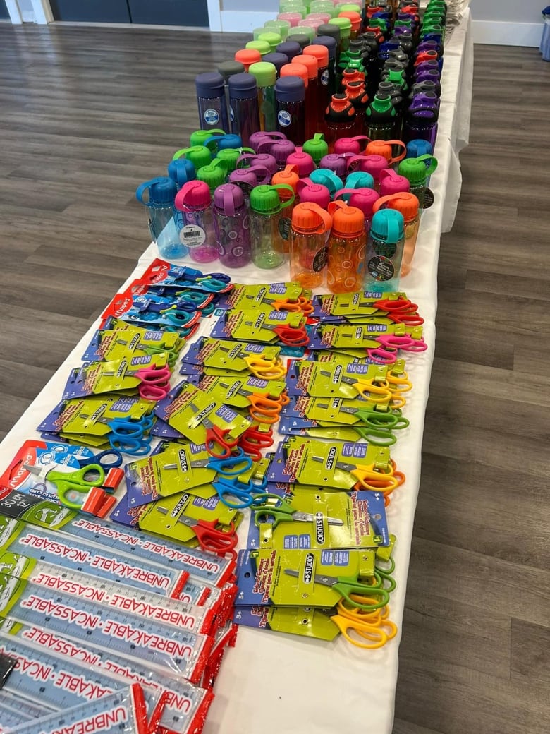 Water bottles and packs of pencils and crayons are shown.