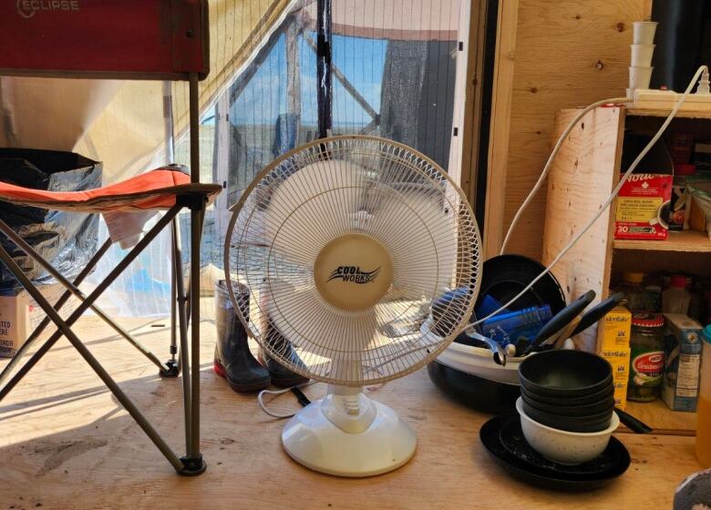 pictures of the inside of a canvas tent with an electric fan on the floor