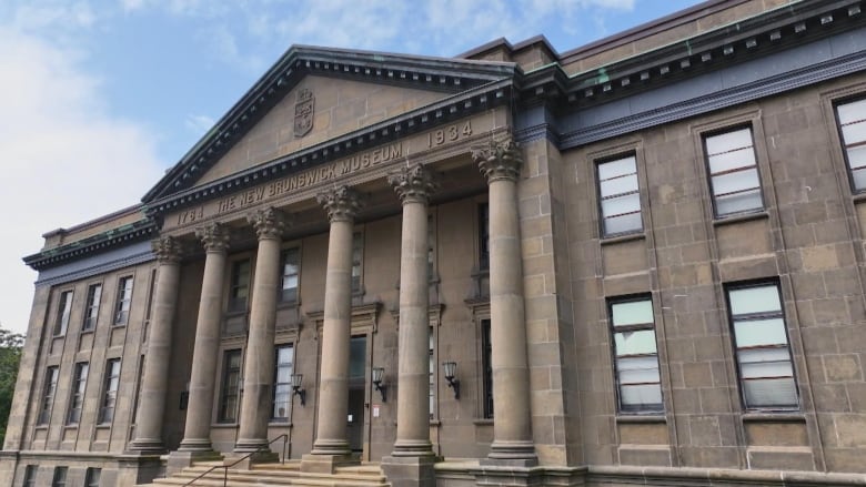 Large, older building pictured from ground looking up on a clear day.