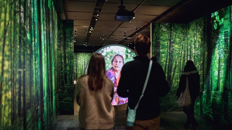 Museum guests watch a video testimonial from the exhibit 