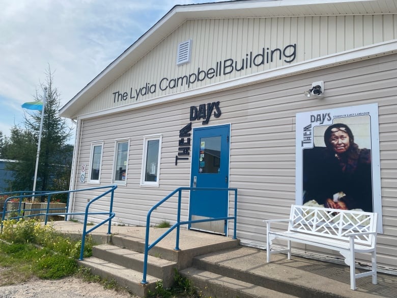 Beige building with a historical picture of an indigenous woman and Them Days logo on it. 