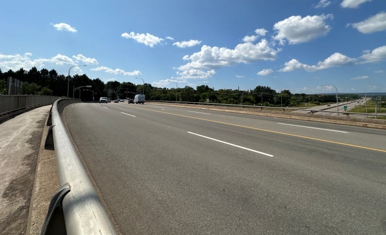 A four-lane roadway with a sidewalk on the left side. 