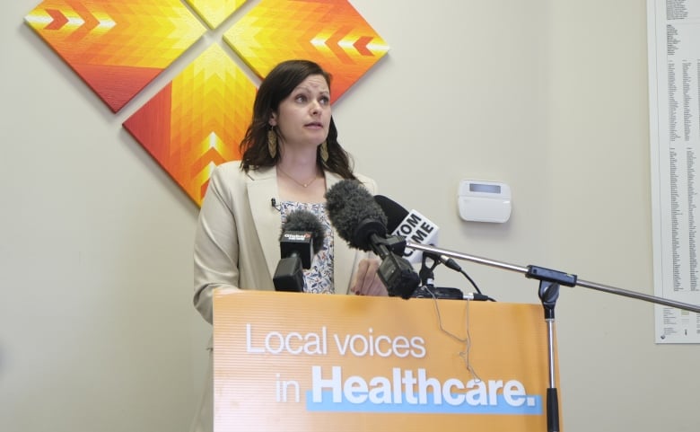 Vicki Mowat is standing at a podium inside her saskatoon office