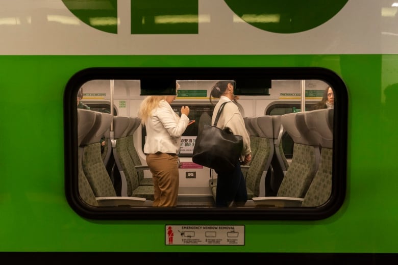 Two female commuters arrive at Union Station on a GO Train, are up from their seats and ready to exist the train