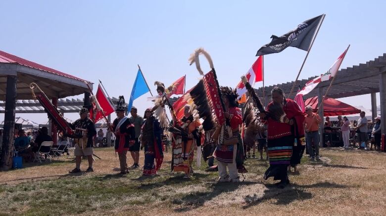 men and boys dancing in regalia at pow wow