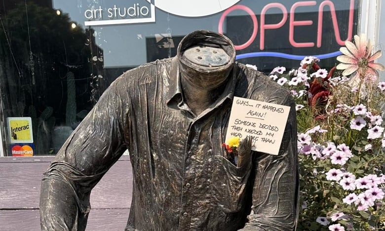 A headless statue sits on a bench