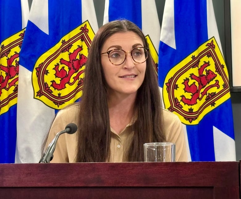 a woman with brown hair wearing glasses 