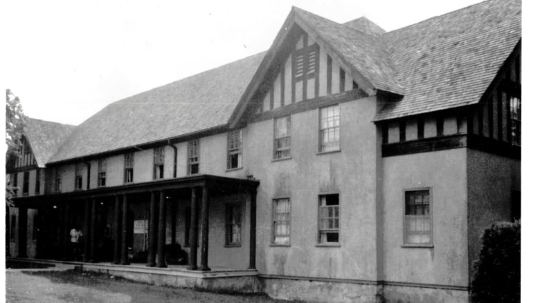 A greyscale photo of a Tudor Revival style building