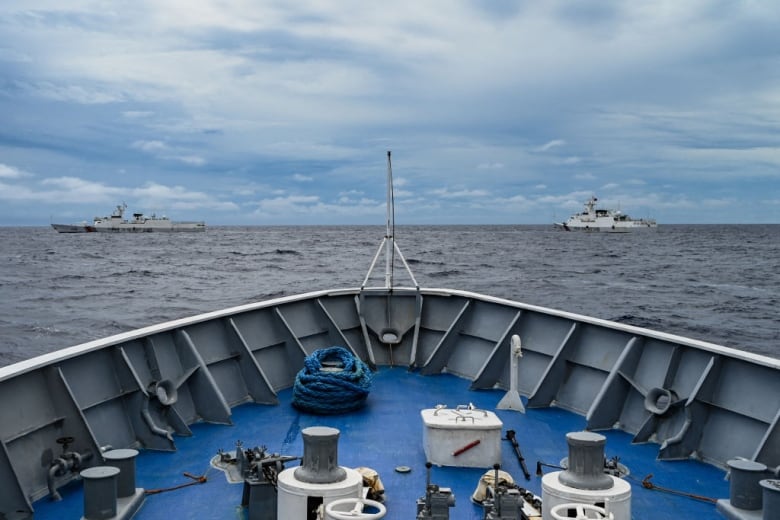 China Coast Guard ships, in the background, are in the South China Sea, with a Philippine Coast Guard vessel in the foreground. 