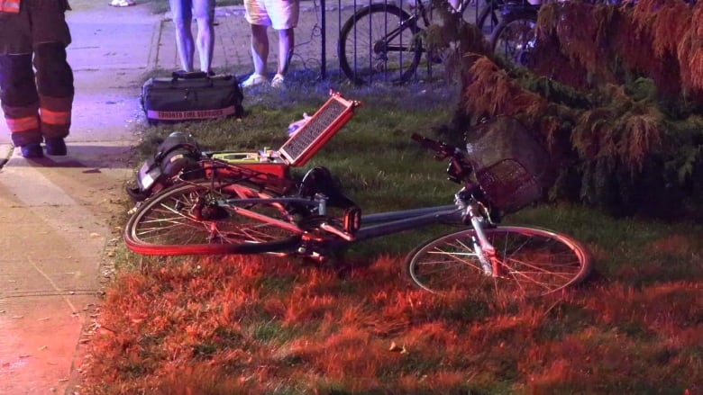 A damaged bike is seen on the side of the road.