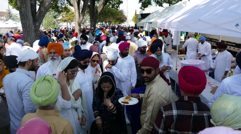 A crowd of people, many wearing turbans and white shirts