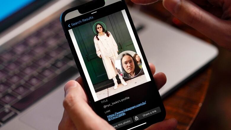 A close-up of hands holding a phone. The screen shows a person with a circle around their face. 