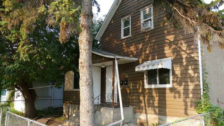 The front of a house with boarded-up windows