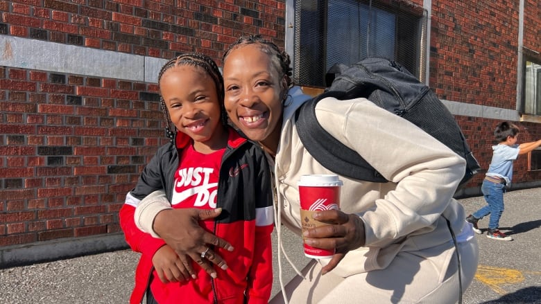 A woman and a child smile for a picture.