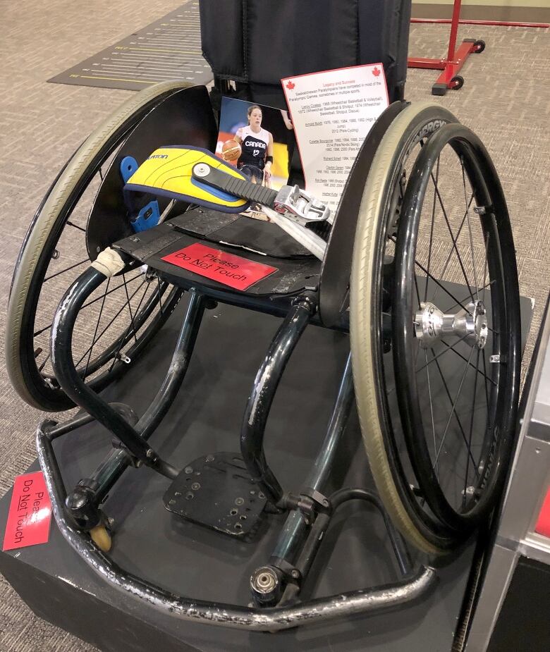 A wheelchair has a photo sat atop it, with other papers nearby.