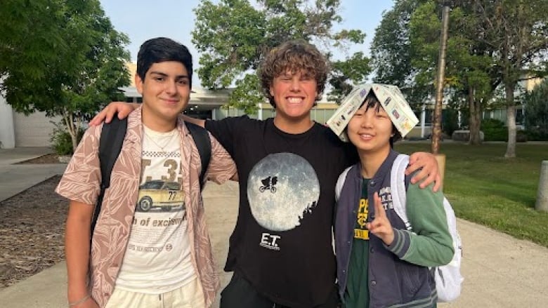 Three students outside a school.