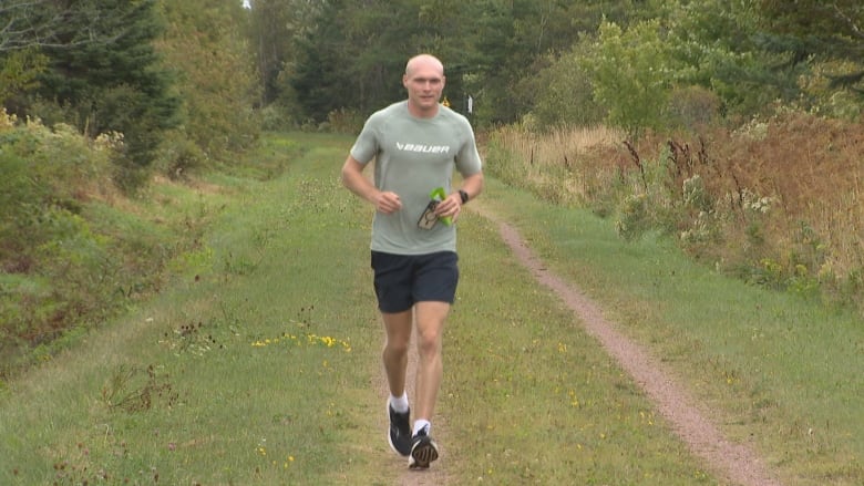 Ryan Keeping running on a wide, grassy trail.