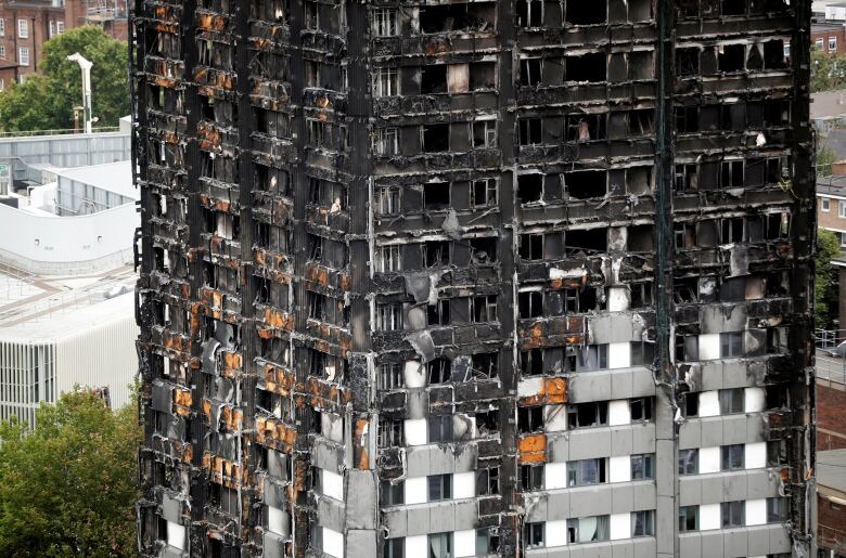 Several floors of a residential high-rise building are shown blackened from fire and hollowed out.