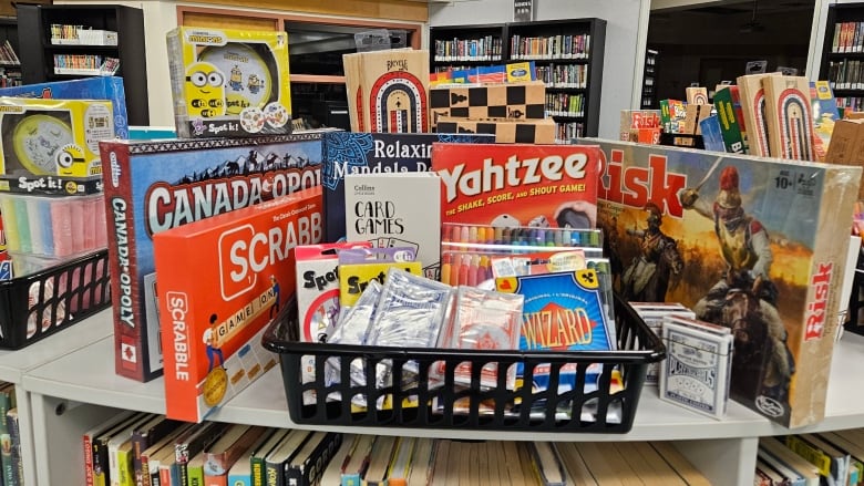 Close up of books and games on a shelf.