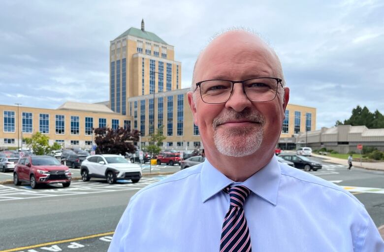 a portrait style photo of Fred Hutton, with Confederation Building in the background.