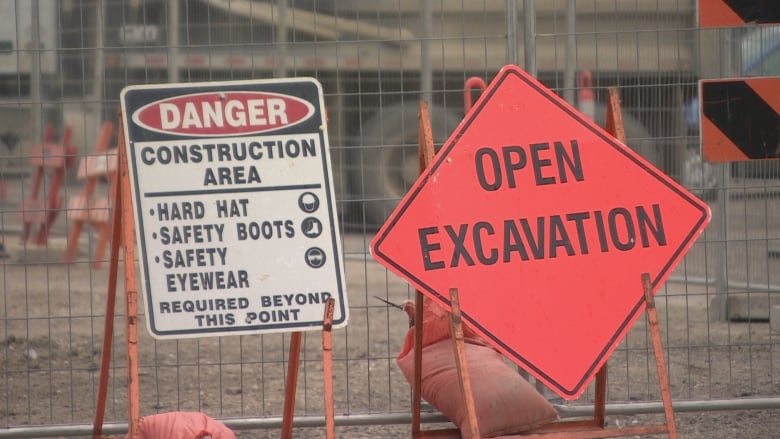 Construction is underway on a street. A sign says 