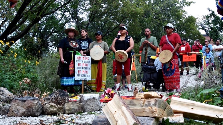 Group of women stand holding drumbs