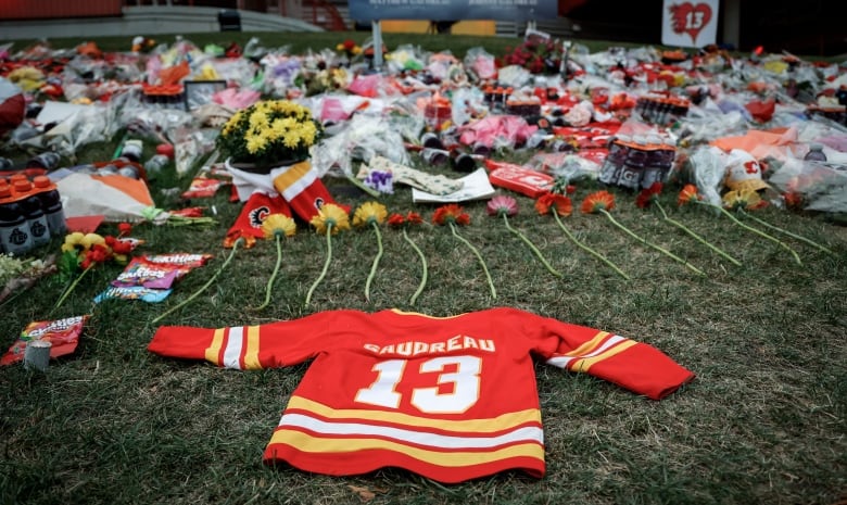 Flowers and memorabilia for former Calgary Flames male player and his brother lie on the grass outside the Saddledome in Calgary, Alta., Wednesday, Sept. 4, 2024. The brothers were struck and killed by a suspected drunk driver last week while cycling near their childhood home in New Jersey. 