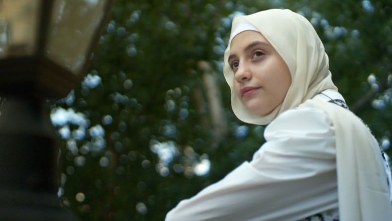 A young girl looks to the side.