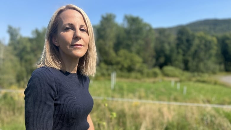 A woman in a field posing for a photo. 